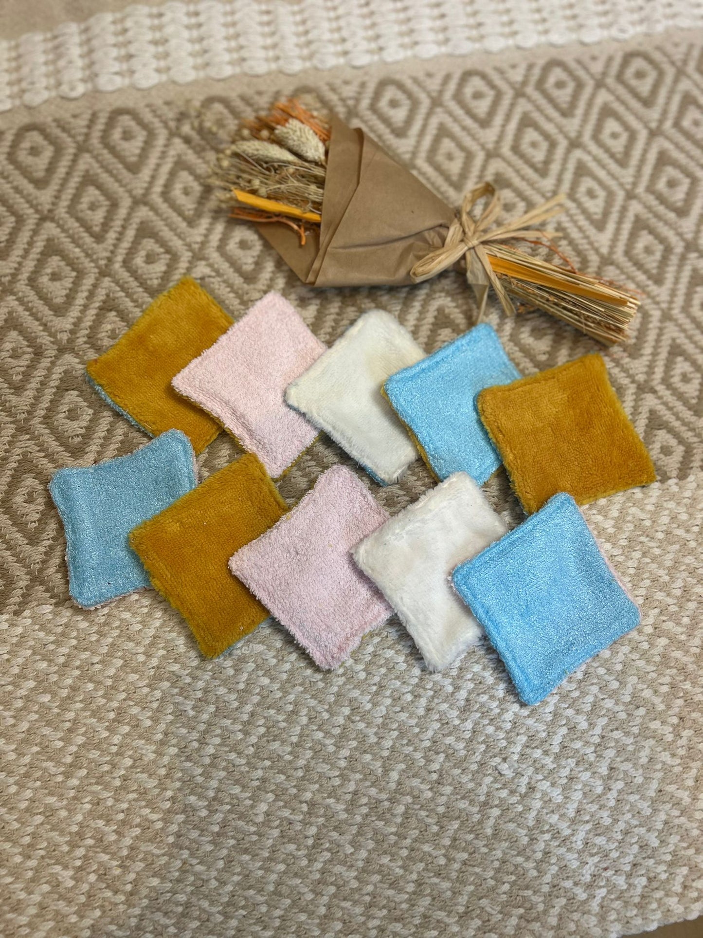 carré de coton démaquillante lavable jaune et blanc en coton et nid d'abeille, sur une tapis