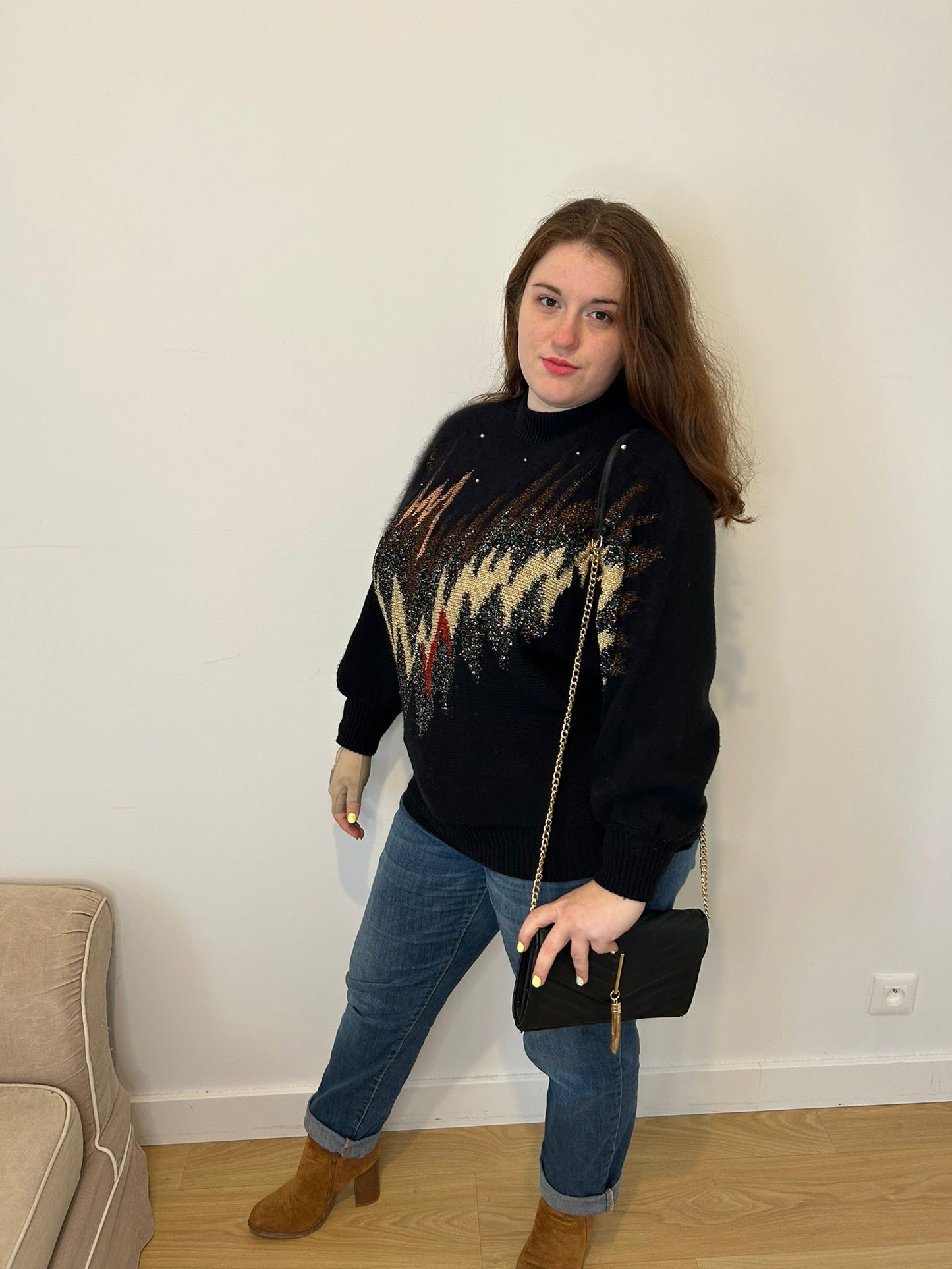 Pull noir et brillant avec perle, femme grande taille en jeans bleu et sac à main noir 