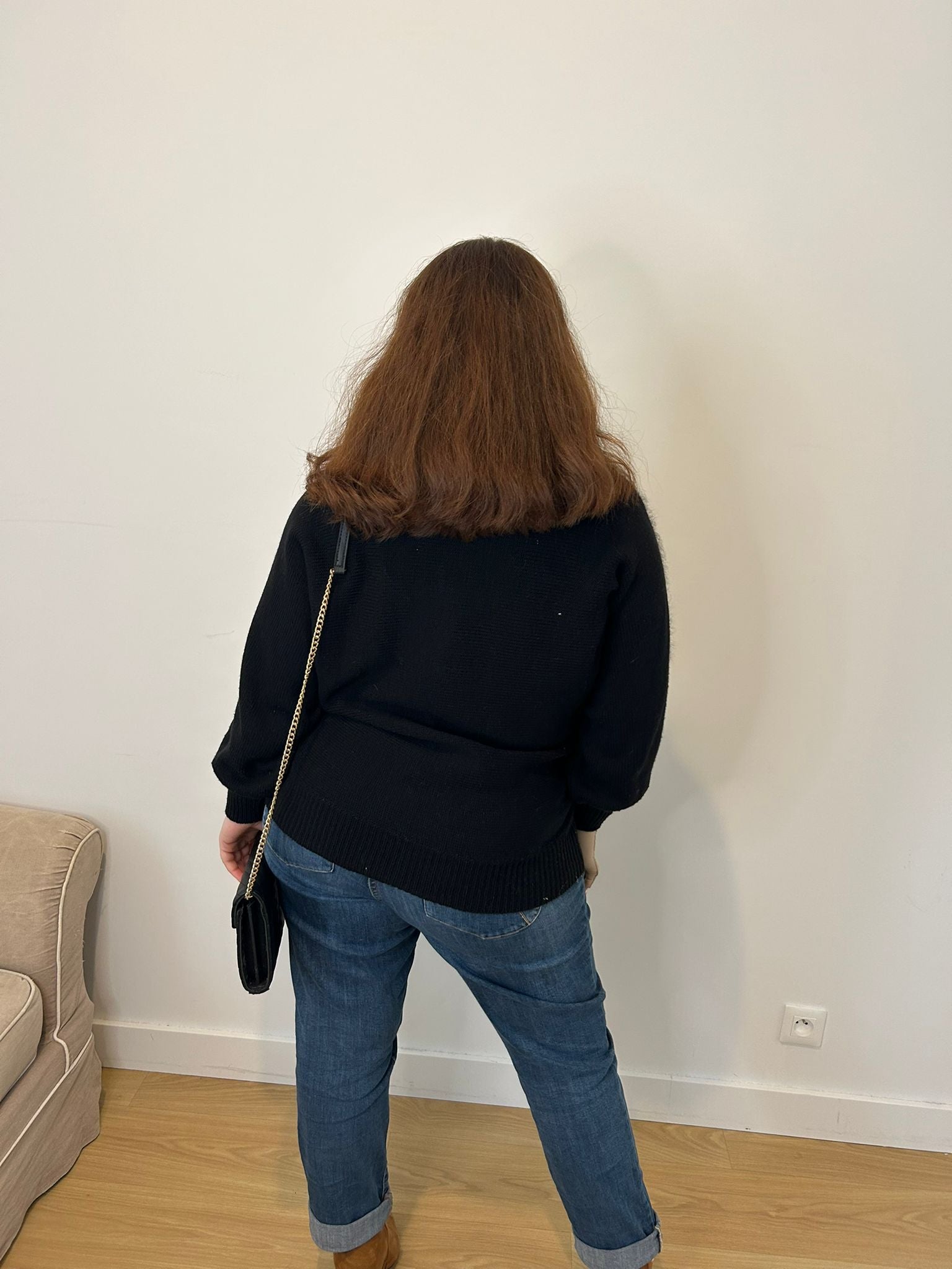 Pull noir et brillant avec perle, femme grande taille en jeans bleu et sac à main noir 