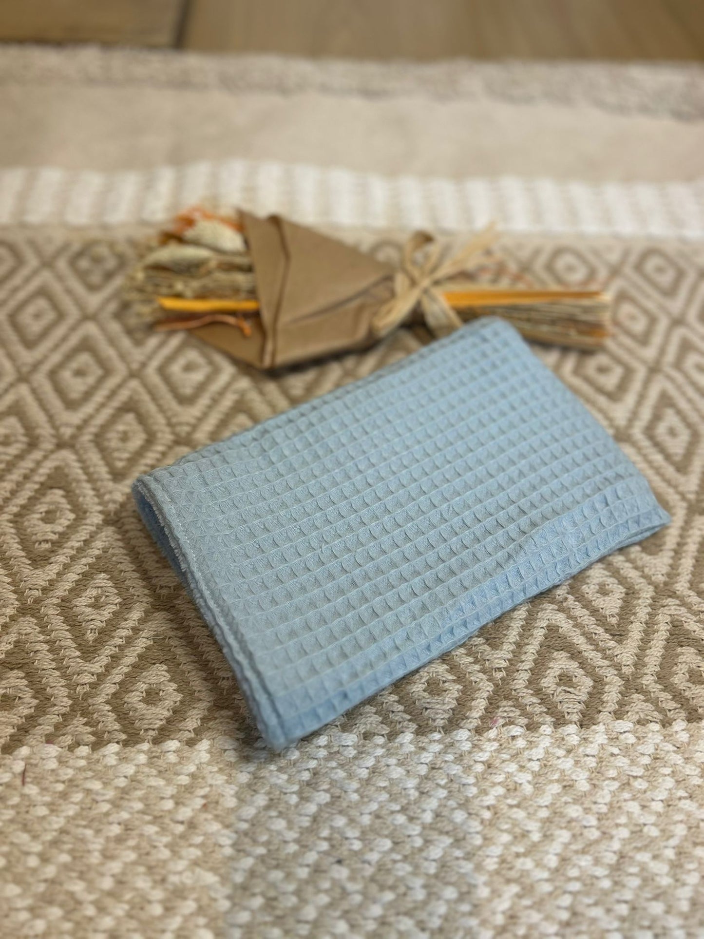 gant de toilette bleu, zero déchet et tapis en fond 
