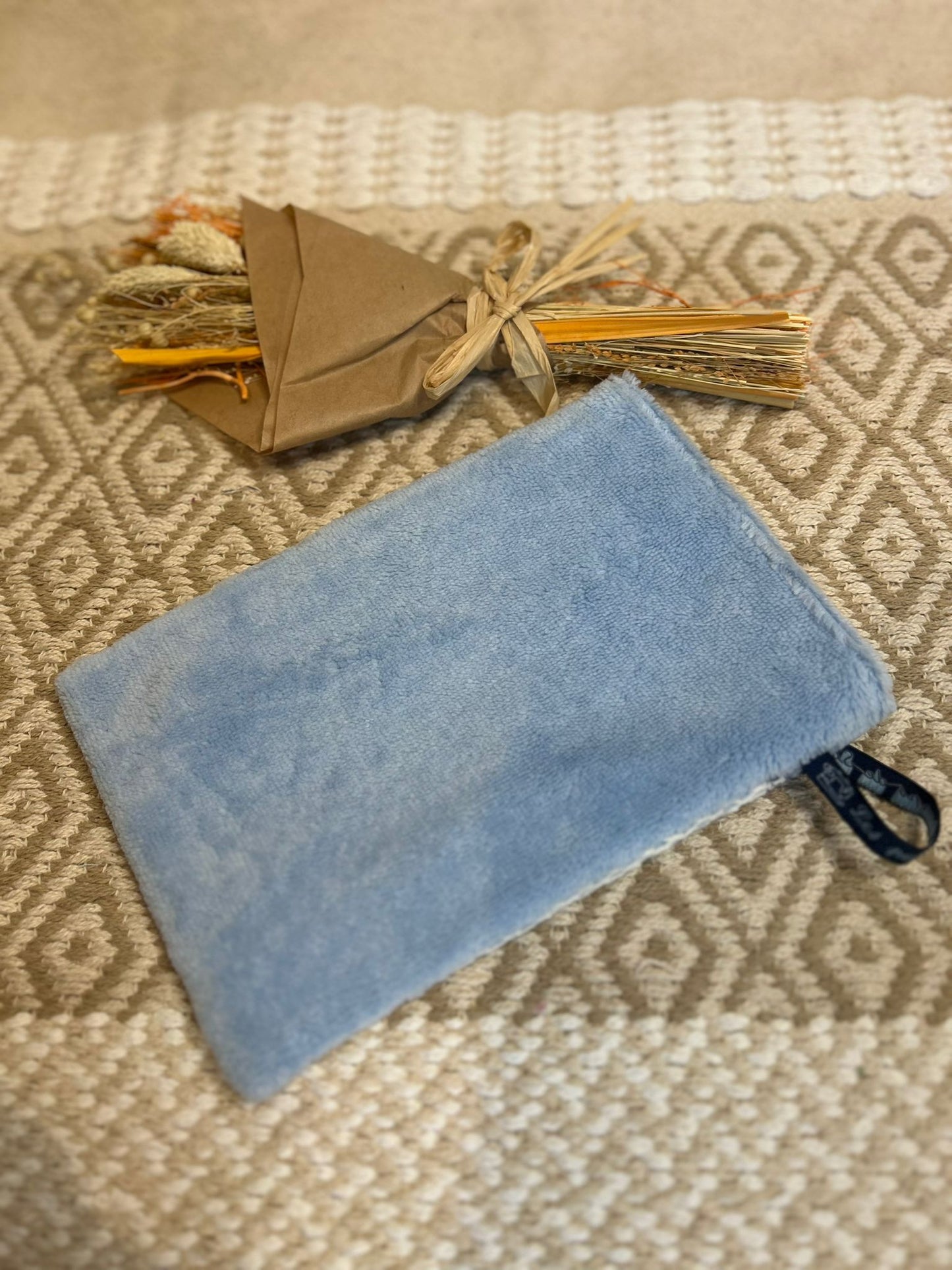 gant de toilette bleu, zero déchet et tapis en fond 
