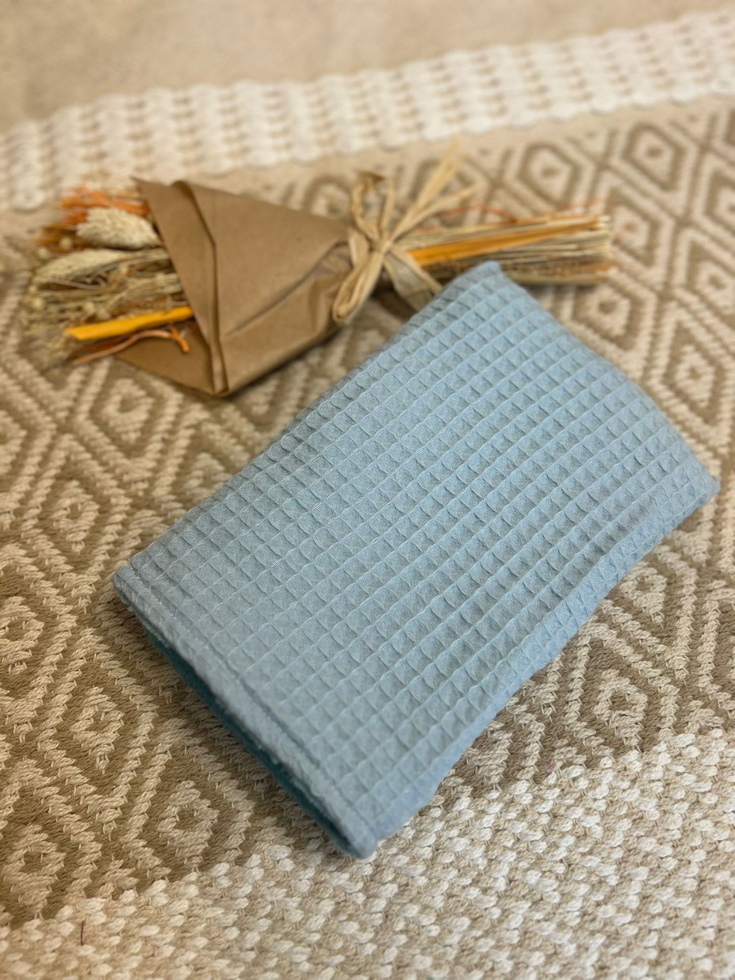 gant de toilette bleu, zero déchet et tapis en fond 
