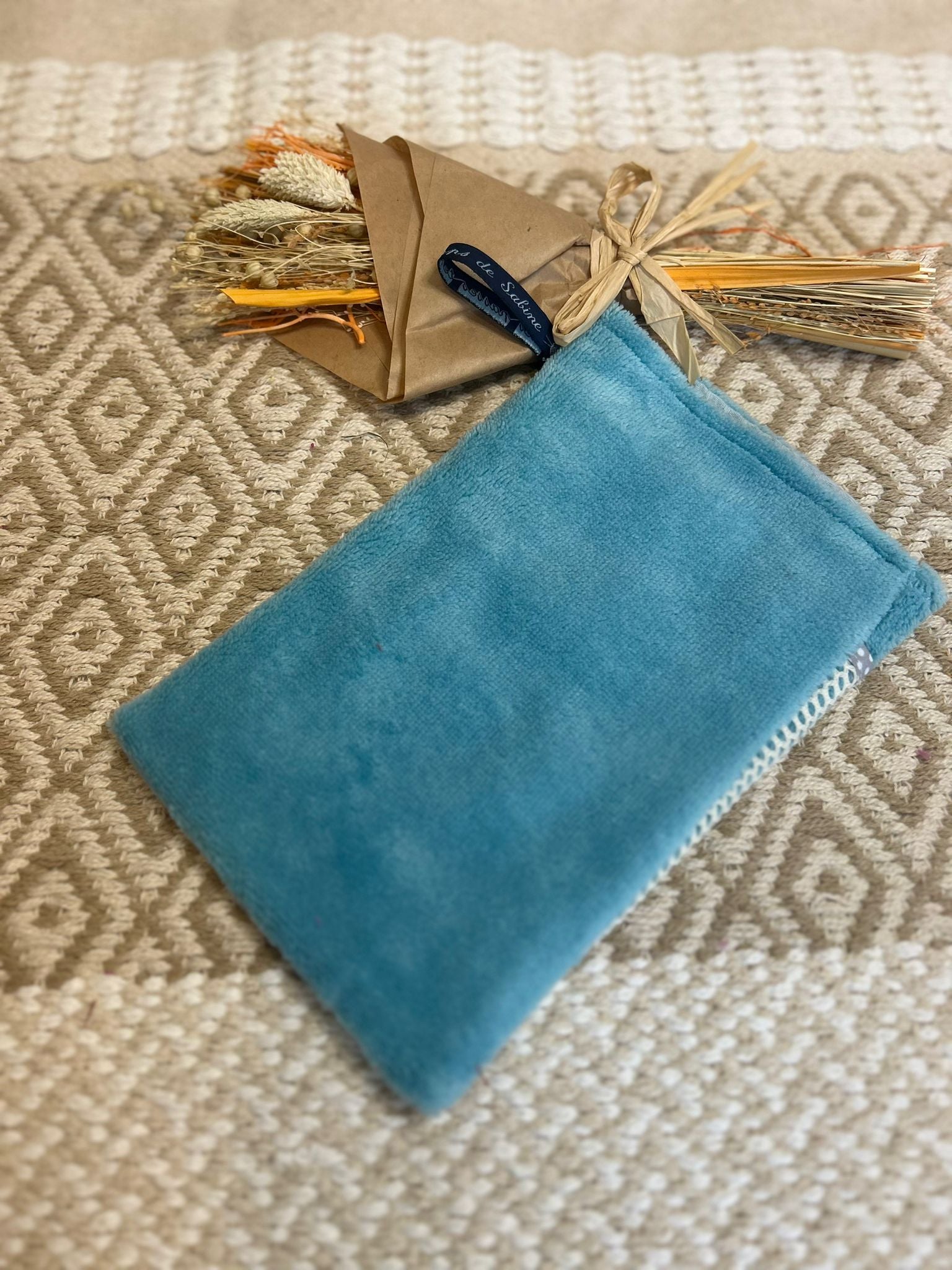 gant de toilette bleu, zero déchet et tapis en fond 
