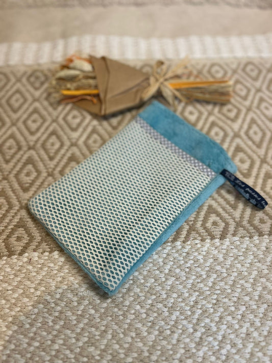 gant de toilette bleu, zero déchet et tapis en fond 
