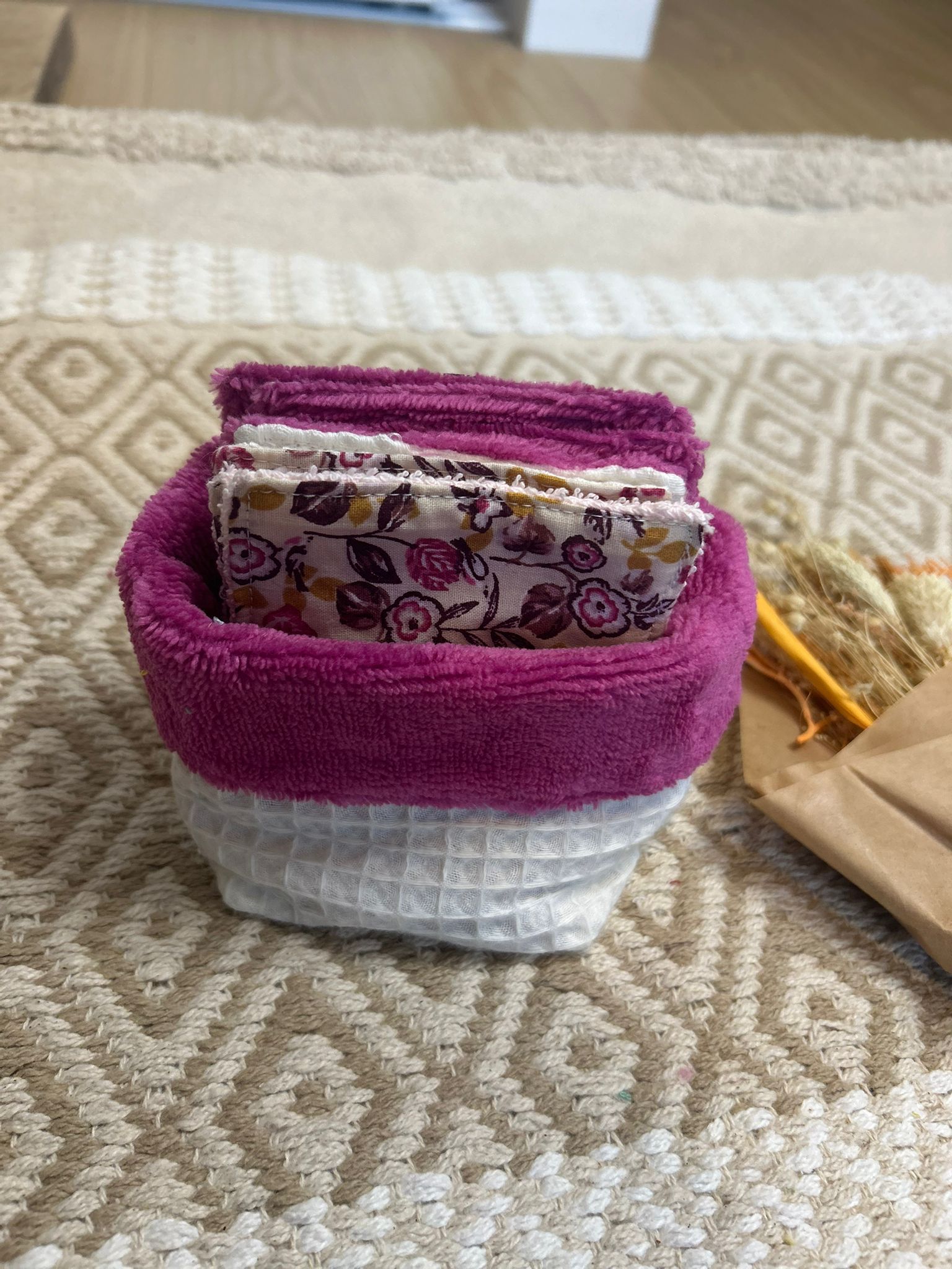 carré de coton démaquillante lavable rose et blanc en coton et nid d'abeille, sur une tapis 