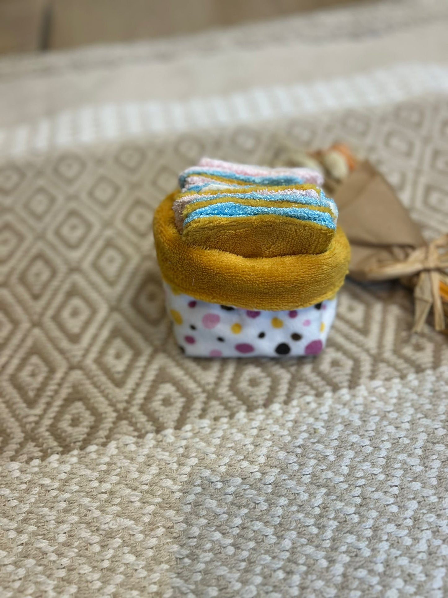 carré de coton démaquillante lavable jaune et blanc en coton et nid d'abeille, sur une tapis 