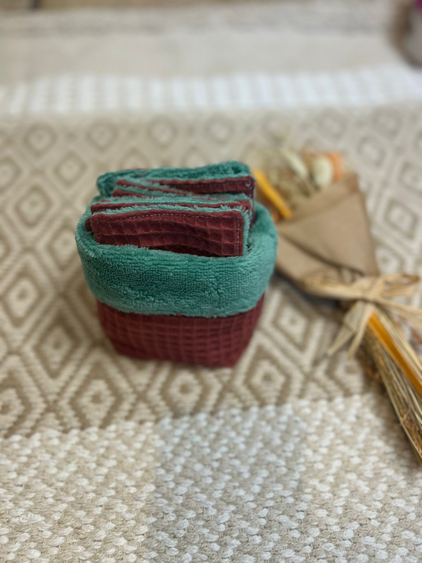 carré de coton démaquillante lavable vert et bordeaux en coton et nid d'abeille, sur une tapis 