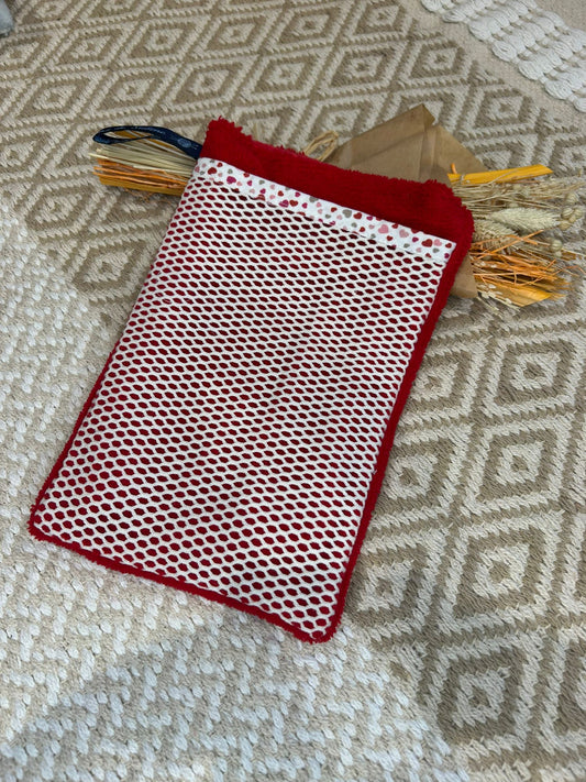 gant de toilette rouge, filet blanc et coeur sur un tapis beige et un bouquet de fleurs sécher 